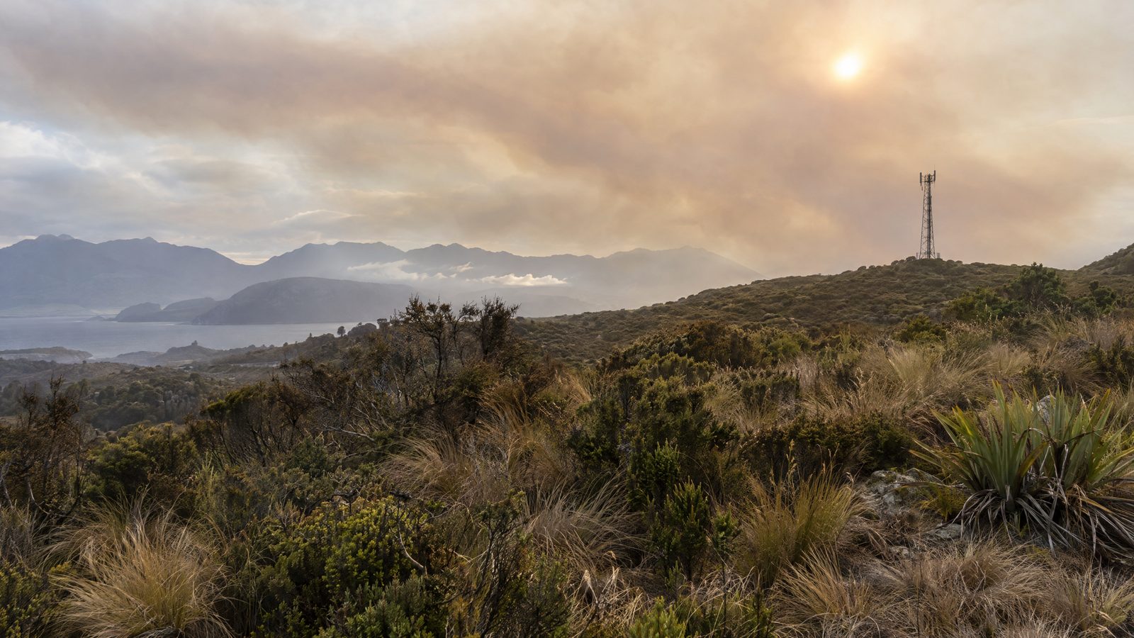 Southland scrub fire remains active as wind limits response and threatens telecommunications towers