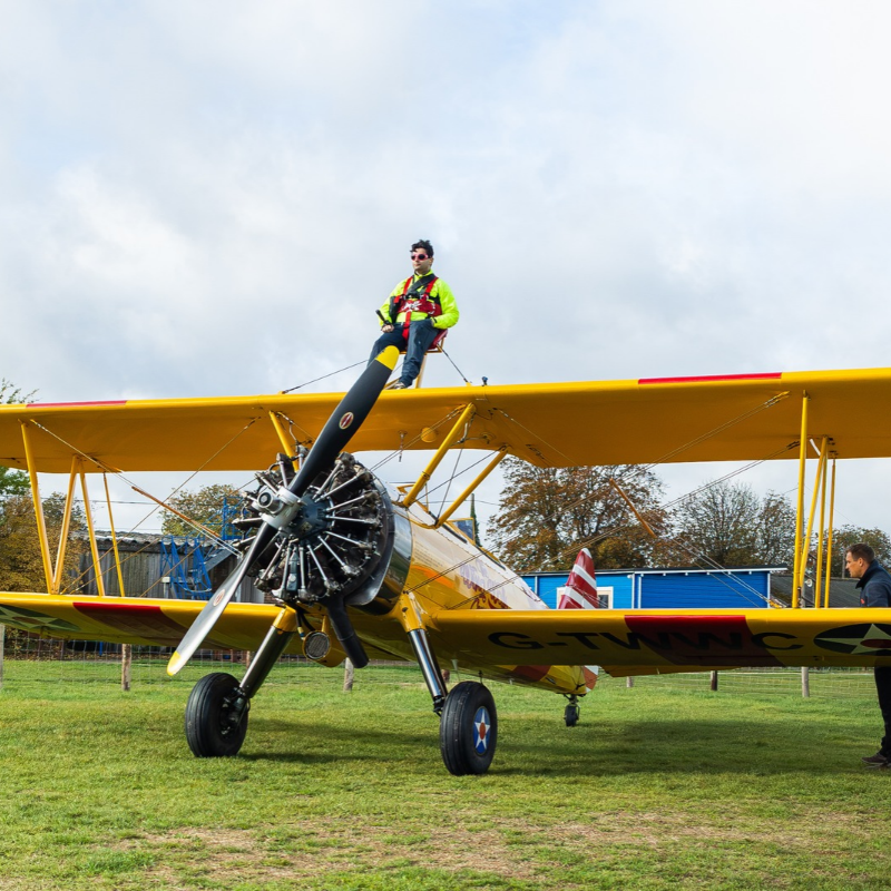 Daredevil collector sets bizarre Guinness World Record by ripping open trading cards while strapped to wing of flying plane